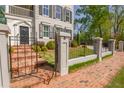 Charming front yard with brick walkway, wrought iron gate, and lush landscaping leading to the inviting front entrance at 3890 The Battery, Duluth, GA 30096