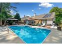 Inviting backyard featuring a sparkling blue pool, lounge chairs, and a covered dining area at 436 Suwanee East Dr, Lawrenceville, GA 30043