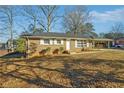 Charming brick home with a covered parking area and a well-maintained front yard at 8586 Taylor Rd, Riverdale, GA 30274