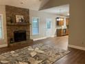 Open floor plan showcasing a stone fireplace, hardwood floors, and seamless transition to the kitchen at 106 Creek Crossing Ln, Temple, GA 30179