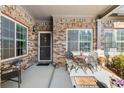 Charming covered porch with brick, a small table set, and beautiful plants at 120 Chastain Nw Rd # 608, Kennesaw, GA 30144