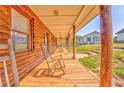 Inviting covered porch with wooden rocking chairs overlooking the home's front yard at 1288 Reavesville Rd, Bowdon, GA 30108