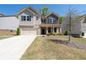 Beautiful two-story home featuring stone accents, a front porch, two-car garage, and landscaped lawn at 1815 Wellston Dr, Lawrenceville, GA 30043