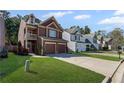 Charming two-story home with a balcony, two-car garage, and manicured lawn at 261 Highland Village Ln, Woodstock, GA 30188