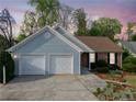Traditional home with a two-car garage, showcasing blue vinyl siding, a brick section and a professionally landscaped front yard at 5265 Bentley Hall Dr, Alpharetta, GA 30005
