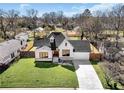 Aerial view of a lovely white brick home with a manicured lawn and mature trees at 1774 Vesta Ave, Atlanta, GA 30337