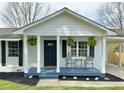 Inviting front porch with black door, fern hangings, and outdoor seating creates curb appeal at 262 E Main St, Rutledge, GA 30663