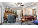 Living room featuring a ceiling fan, stone fireplace, and comfortable furniture at 4941 N Helton Rd, Winston, GA 30187