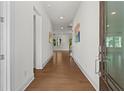 Bright hallway featuring hardwood floors and white walls leads to open, sunlit rooms at 779 Keystone Dr, Woodstock, GA 30188