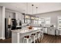 Bright kitchen with granite island, pendant lights, stainless appliances, and stylish backsplash at 1008 Knoxboro Ln, Woodstock, GA 30188