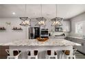 Modern kitchen boasts an island with granite counters, pendant lighting, and stainless steel appliances at 1008 Knoxboro Ln, Woodstock, GA 30188