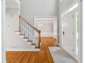Bright foyer with hardwood floors, staircase, and view into the adjacent living area at 1755 Pinetree Pass Sw Ln, Lilburn, GA 30047