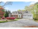 Charming home showcasing a well-manicured lawn, mature landscaping, a brick facade, and a convenient two-car garage at 4086 Norton Se Pl, Smyrna, GA 30082