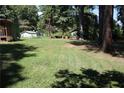 Expansive backyard featuring lush grass, mature trees, and outbuildings at 5048 Westbrook Rd, Union City, GA 30291