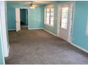 An interior view of a carpeted living room with turquoise walls, a ceiling fan and double doors at 5048 Westbrook Rd, Union City, GA 30291