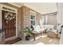 Inviting front porch with comfortable bench seating, decorative wreath, and stylish outdoor decor at 75 Glen Abbey Cir, Fairburn, GA 30213