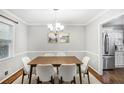 Dining room with table, chandelier, stainless steel refrigerator, and ample natural light at 133 Cross Gate Dr, Marietta, GA 30068