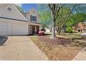 Beautifully landscaped front yard with mature trees framing a charming home with a two-car garage at 4070 Amber Leaf Dr, Roswell, GA 30076