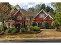 Attractive red brick home featuring lush landscaping and a well-maintained lawn at 225 Cotton Field Ct, Alpharetta, GA 30022
