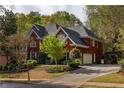 Red brick two-story home with mature landscaping and a two-car garage at 225 Cotton Field Ct, Alpharetta, GA 30022