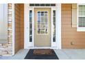 Inviting front door with glass panels, white trim, and a welcome mat on the porch at 2319 White Alder Dr, Buford, GA 30519
