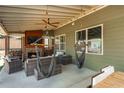 Charming outdoor patio with fireplace, ceiling fan, and hanging hammock chairs; perfect for relaxation at 5390 Chestnut Dr, Cumming, GA 30040