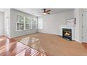Bright living room with a cozy fireplace, ceiling fan, and lots of windows overlooking the backyard at 2732 Pierce Brennen Ct, Lawrenceville, GA 30043