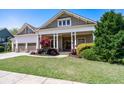 Inviting home with a covered front porch, a manicured lawn, and a lovely landscaped garden at 3137 Perimeter Cir, Buford, GA 30519