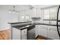 Bright kitchen with stainless steel dishwasher, white cabinets, and a breakfast bar at 6940 Roswell Rd # 24E, Sandy Springs, GA 30328