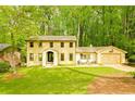 Charming yellow brick home featuring a well-manicured lawn and a lush, wooded backdrop at 2433 Helmsdale Ne Dr, Atlanta, GA 30345