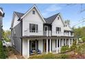 Stylish two-story home featuring gray and white siding with a cozy front porch and balcony at 1911 Commons Cir, Brookhaven, GA 30341