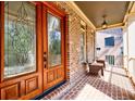 Covered porch with brick flooring, seating, and decorative glass front door at 2141 Abby Ne Ln, Atlanta, GA 30345