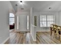 Bright foyer with hardwood floors, a white front door, and a view into other living spaces at 1965 Winnstead Pl, Loganville, GA 30052