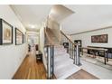 Bright foyer with hardwood floors, staircase with black iron railing, and views into the living areas at 989 Vendue Dr, Lawrenceville, GA 30044