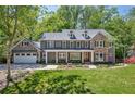 Beautiful two-story home with stone accents, a manicured lawn, and an attached two-car garage at 4152 Club Ne Dr, Atlanta, GA 30319