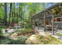 Covered patio and open backyard with room for dining and entertaining, surrounded by lush greenery at 5515 Cross Gate Ct, Sandy Springs, GA 30327