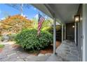Inviting covered porch with stone floor, flag, columns, and lush landscaping at 5515 Cross Gate Ct, Sandy Springs, GA 30327