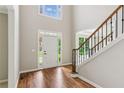 Bright foyer featuring hardwood floors, a staircase with black iron spindles, and high ceilings with transom windows at 7020 Weybridge Dr, Cumming, GA 30040