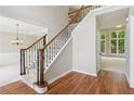 Carpeted staircase with wood and black iron railing, leading to upper level, adjacent to hardwood flooring at 7020 Weybridge Dr, Cumming, GA 30040