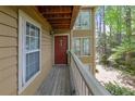 View of condo entrance with red door, porch, and natural green surroundings at 907 Country Park Se Dr, Smyrna, GA 30080