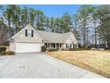 Well maintained single-story home with a long driveway leading to the attached two-car garage at 1935 Knight Cir, Loganville, GA 30052