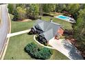 Aerial view of a property with a well-maintained lawn, in-ground swimming pool and long driveway at 7804 Gusty Trl, Douglasville, GA 30135