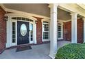 Inviting front porch with brick columns and a detailed front door, creating a warm entry at 7804 Gusty Trl, Douglasville, GA 30135