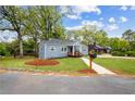 Landscaped front yard featuring manicured lawn and a mailbox near the road. The charming home has gray paint and brick at 1623 Athens Sw Ave, Atlanta, GA 30310