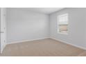Neutral bedroom featuring a carpeted floor, one window with blinds, and a door at 342 Orwell Dr, Social Circle, GA 30025