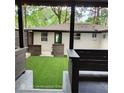 Inviting backyard featuring artificial grass, dark stained wood fence and columns, and a white painted brick house at 3572 Adkins Nw Rd, Atlanta, GA 30331