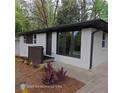 Charming exterior view of a painted white brick home with dark window trim and professionally landscaped yard at 3572 Adkins Nw Rd, Atlanta, GA 30331