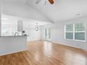 Bright open-concept living area with wood floors, vaulted ceilings, and French doors to the backyard at 135 Kimbell Farm Dr, Locust Grove, GA 30248