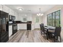 Bright kitchen with white cabinets, black appliances, and a dining area with large window at 2831 Pine Log Way, Buford, GA 30519