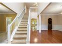 Bright foyer with hardwood floors and a staircase leading to the upper level, creating an inviting entry at 4312 Defoors Farm Trl, Powder Springs, GA 30127